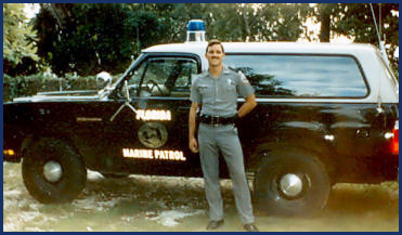 Dan Adams beside a Florida Marine Patrol vehicle