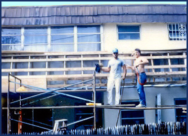 Dan Adams working on a building exterior from scaffolding